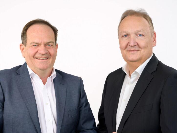 Die beiden Geschäftsführer von Kaffee Partner Jorg Baumgart (CEO) & Roger Lang (CFO) stehen Seite an Seite und lächeln in die Kamera