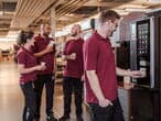 Team-kaffeepause-gruppe-mitarbeitende-kaffeemaschine