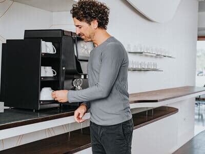 Tassen und Kaffeebecher ordentlich angeordnet in einer Kaffeebar