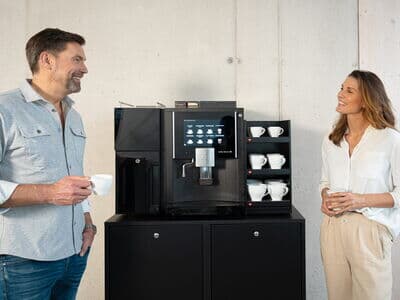 Vollausgestatteter Kaffeevollautomat mit aufgewärmten Tassen und frischer Milch