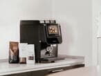 Barista-suprema-mit-kaffeebohnen-und-topping