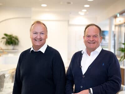 Die beiden Geschäftsführer von Kaffee Partner Jorg Baumgart (CEO) & Roger Lang (CFO) stehen Seite an Seite und lächeln in die Kamera