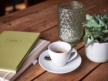 Pressemeldungen auf einem Tisch mit einem Kaffee Crema