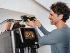 Person-füllt-kaffeebohnen-in-barista-ultima